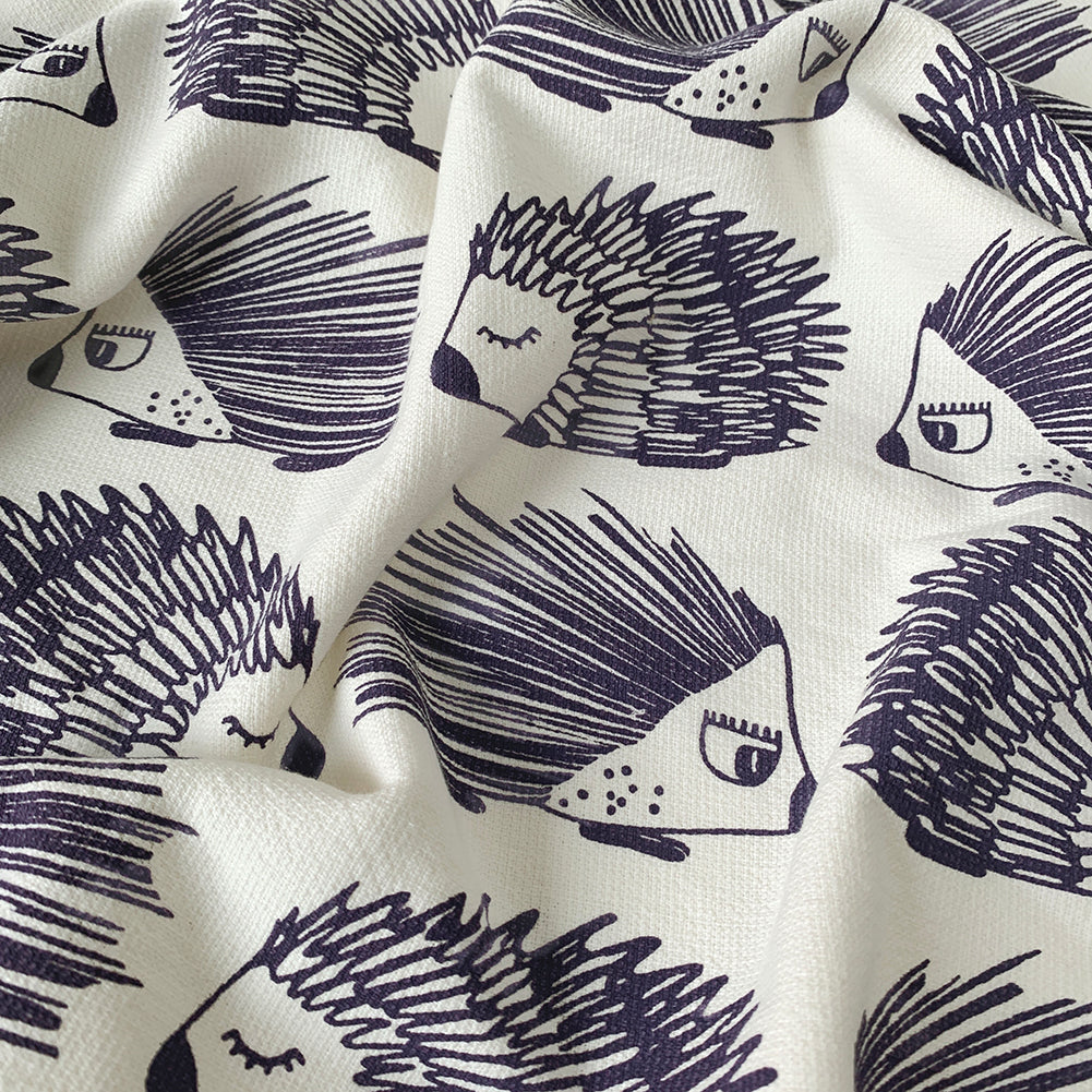 A close up of a Mapayah cotton bath towel featuring a porcupine print, neatly folded to show the design, fabric quality, and softness.