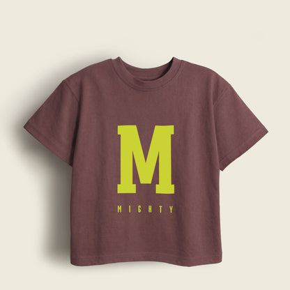 Brown kids t-shirt with a large yellow 'M' and 'MIGHTY' text on a beige background