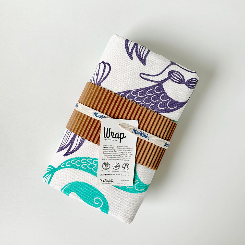 Mapayah green cotton bath towel with mermaid print, neatly packed in a sleeve, showing its size and design.