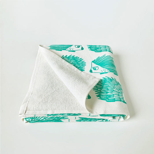 
Mapayah cotton bath towel featuring a green porcupine print, neatly folded to show the design, fabric quality, and softness.

