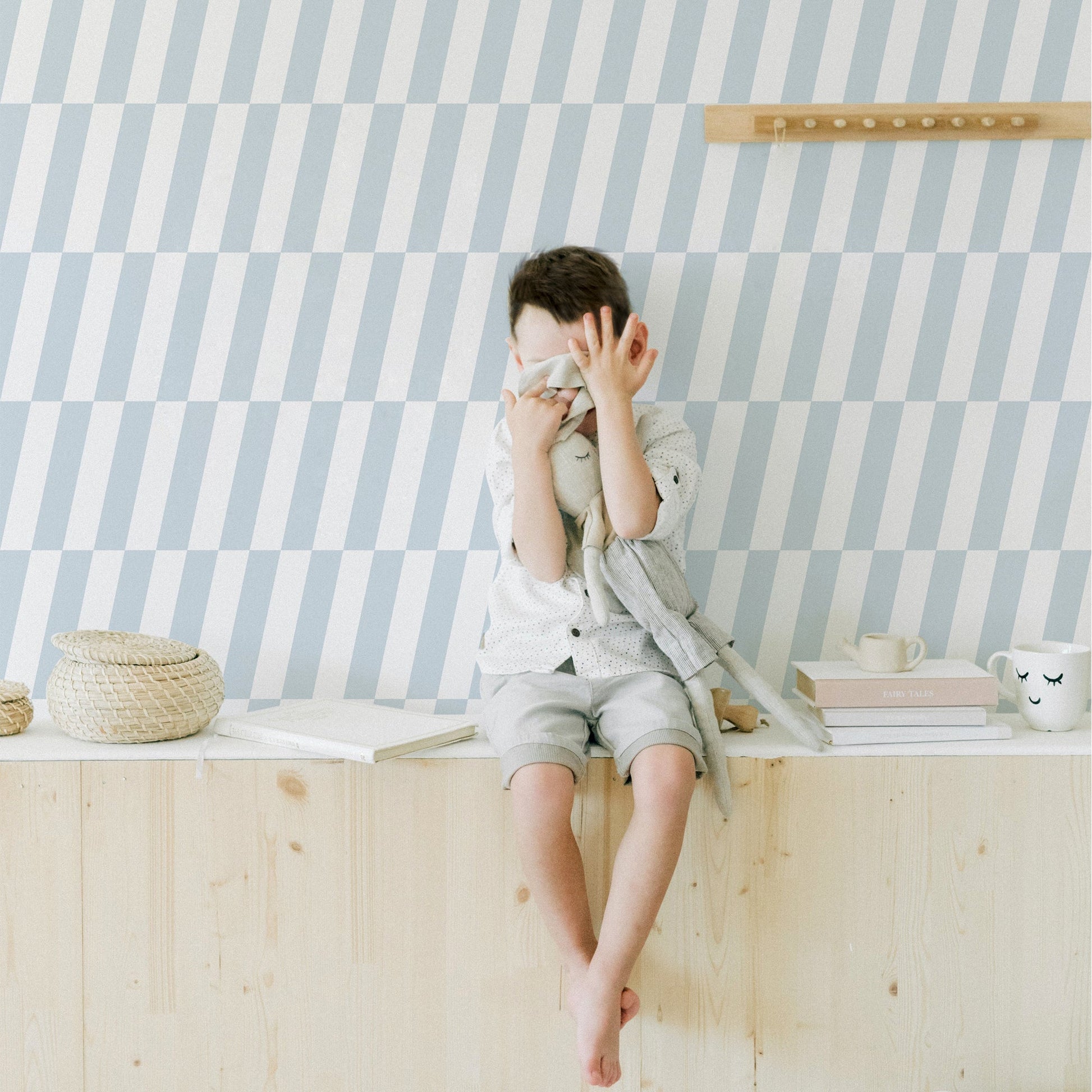 Mapayah DECK Tilt kids room wallpaper in blue, styled in a bedroom setting