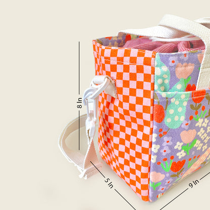 A fabric lunch bag with multiple colorful patterned panels, including orange and white checkers and a floral print on lavender, shown with white straps and overlaid dimension lines indicating 8 in height, 5 in width, and 9 in depth.