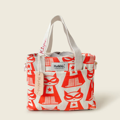 A canvas lunch bag featuring a red super cat pattern, with off-white fabric handles and a visible 'Mapayah' brand label and personalised name on bag strap.