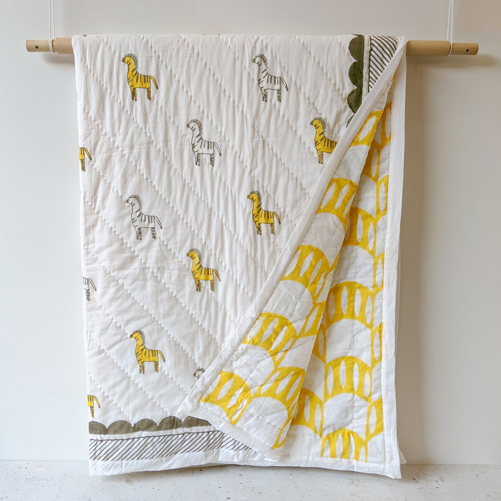 Mapayah SNUGGLE Zany Zebra kids blanket shown hanging alongside a folded blanket