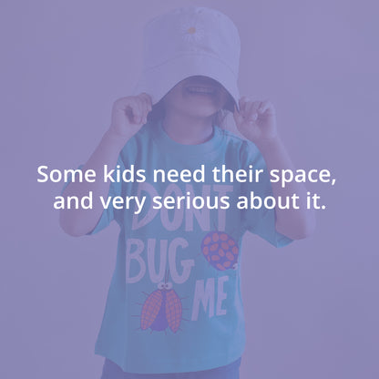 Kid wearing a cap and t-shirt with text, against a purple background