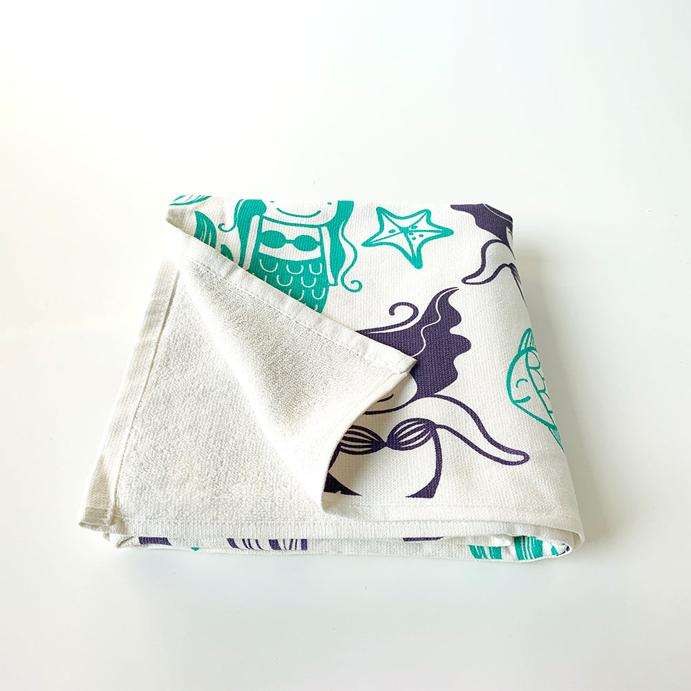 Mapayah cotton bath towel featuring a mermaid print, neatly folded to show the design, fabric quality, and softness.

