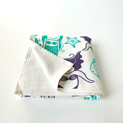 Mapayah cotton bath towel featuring a mermaid print, neatly folded to show the design, fabric quality, and softness.

