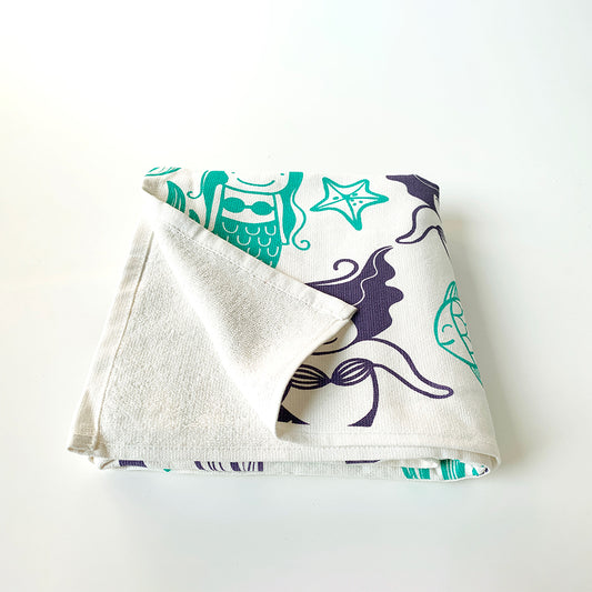Mapayah cotton bath towel featuring a mermaid print, neatly folded to show the design, fabric quality, and softness.

